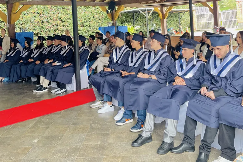 Cuatro estudiantes de bachillerato del Colegio Anglo Español trabajando con sus guías en la mesa del corredor
